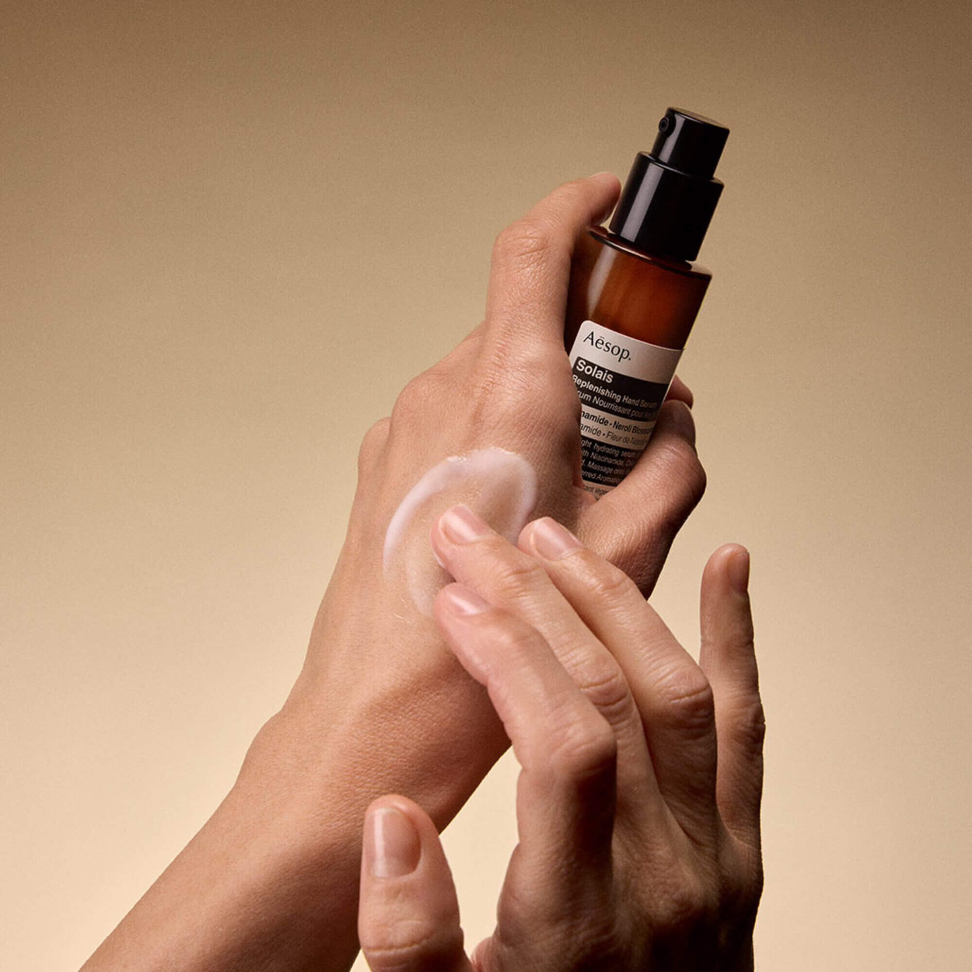 Solais Replenishing Hand Serum in un flacone di vetro.